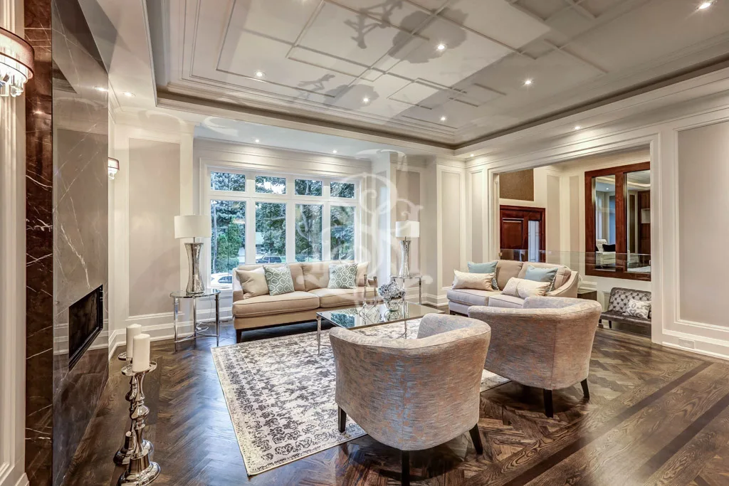 Staged living room in Toronto with neutral sofas and glass coffee table